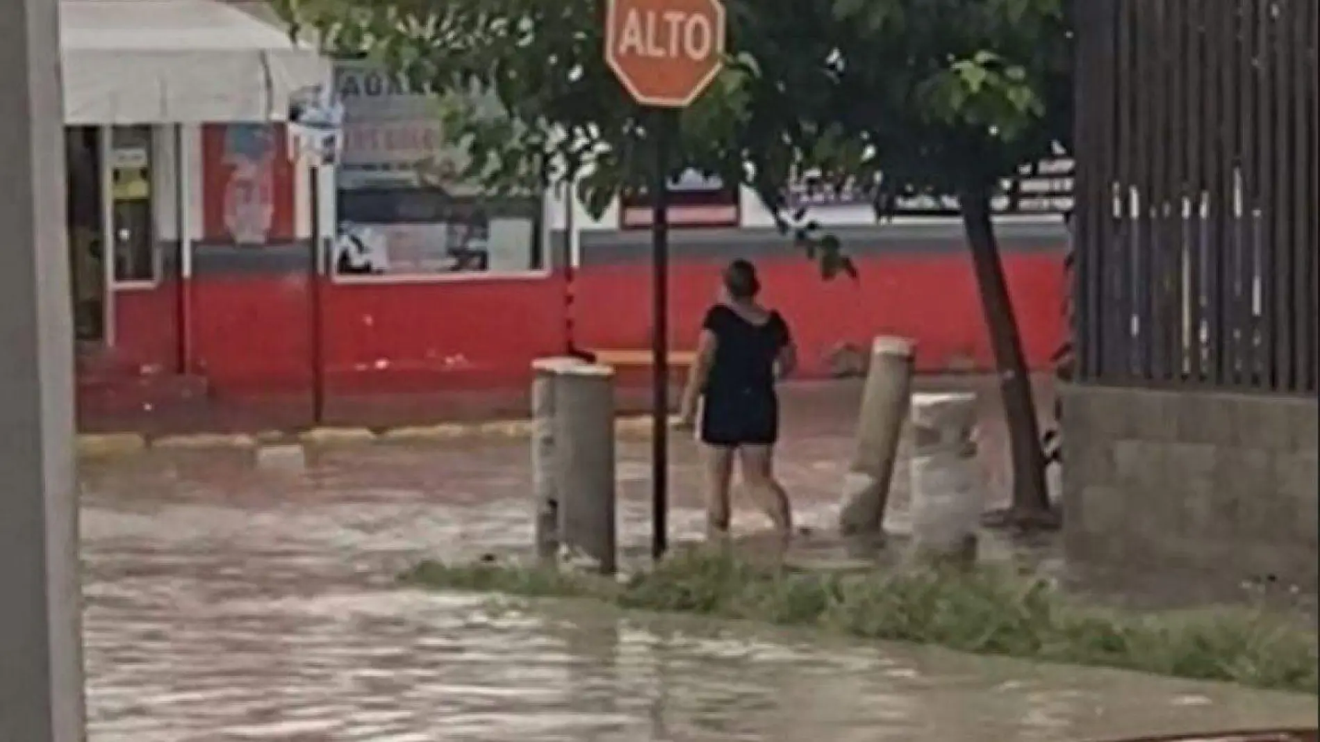 Mujer cruza calles inundadas con tal de comprar una Coca Cola